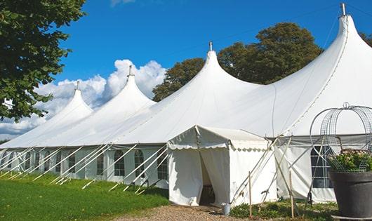 tall green portable restrooms assembled at a music festival, contributing to an organized and sanitary environment for guests in Attica